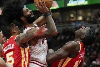 Coby White (au centre) va au contact avec Clint Capela (à droite). KEYSTONE/AP/Erin Hooley